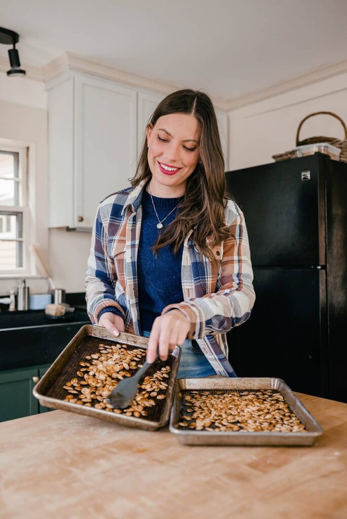 image of woman smiling and holding a tray of roasted pumpkin seeds