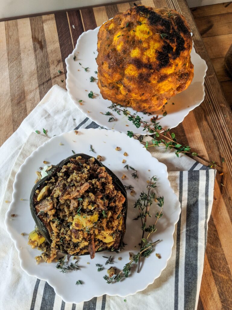 overhead image of stuffed acorn squash and roasted cauliflower on plates