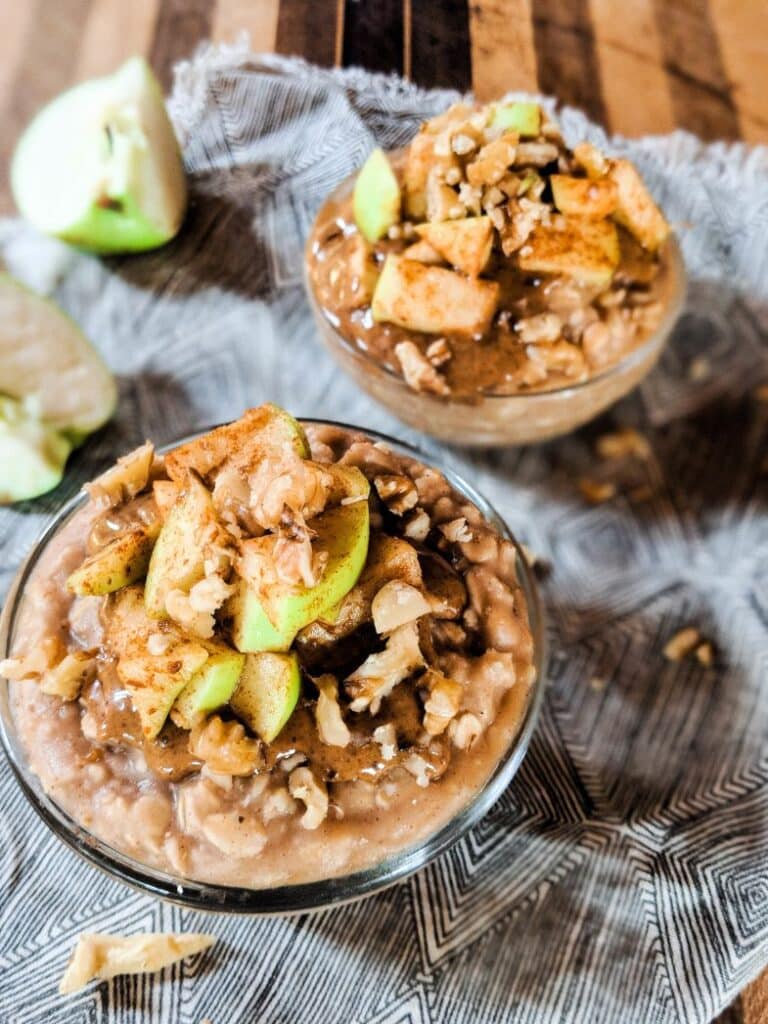 close up overhead image of overnight oats topped with cinnamon, apples, and walnuts